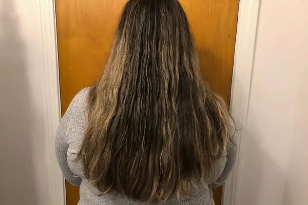 A person showing their hair before using the Halo Hair Labs Icy Halo Heatless Curling Kit 