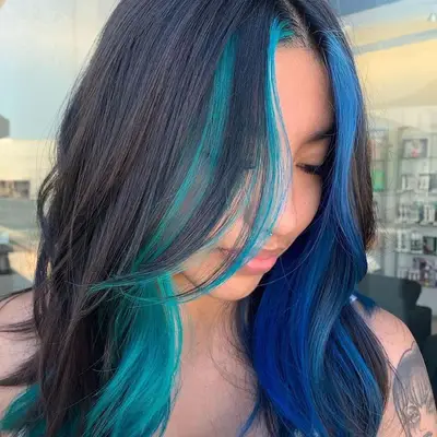 With her head bowed, a model shows off her mermaid-blue waves