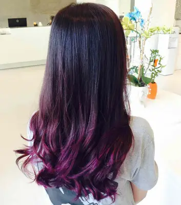 A woman with purple highlights and balayage