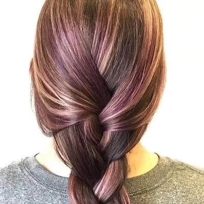 Loosely braided brown hair with blonde and purple highlights