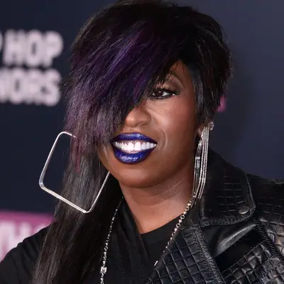 Missy Elliott wears an asymmetrical haircut with purple highlights