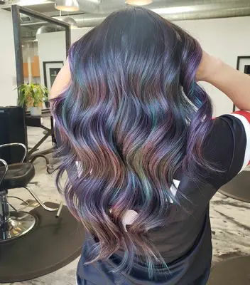 A woman with dark hair and oil slick highlights in purple shades