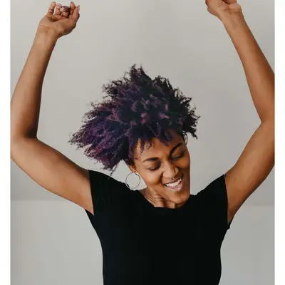 person with purple hair dancing happy