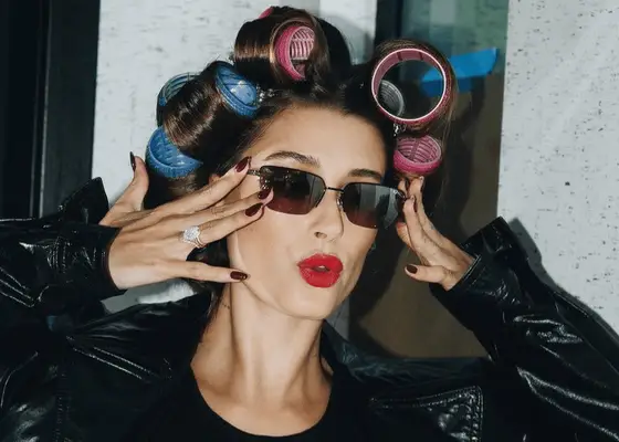 Hailey Bieber with blue and pink hair rollers in her hair