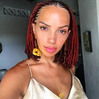 A woman with red box braids in a bob