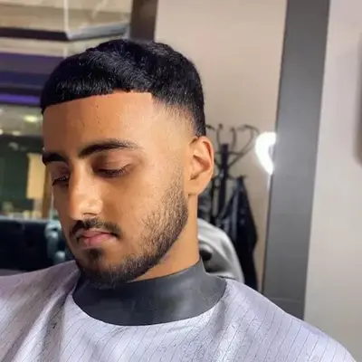 Man with short bowl cut hairstyle with faded sides and short facial hair