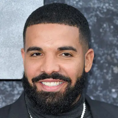 Drake wears a clean-cut Caesar haircut with his signature beard