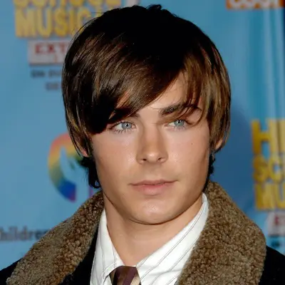 Zac Efron wears a sideswept fringe hairstyle