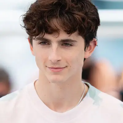 Timothee Chalamet wears a tousled wavy fringe haircut