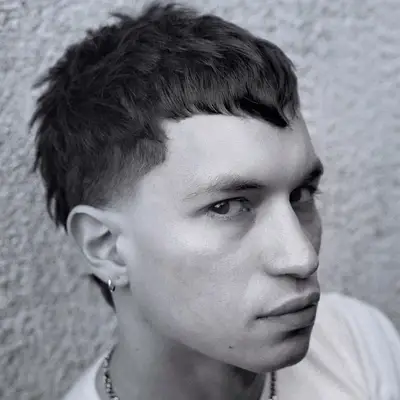 Man wears a pointy fringe mullet haircut