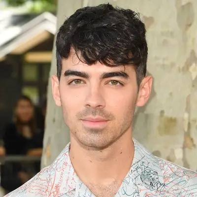 Joe Jonas wears a sleek and wavy fringe haircut
