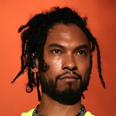 Miguel wears medium-length dreadlocks