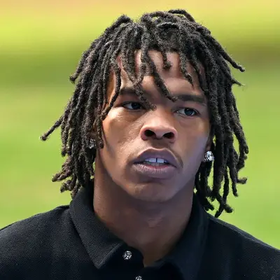 Lil Baby wears medium-length dreadlocks with fringe