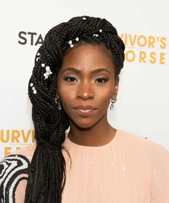Teyonah Parris with side-swept twisted box braids with white flowers on the red carpet