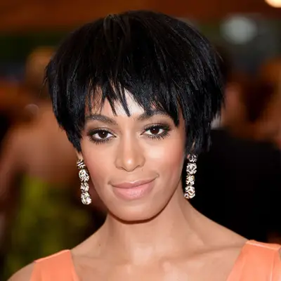Solange Knowles with rounded pixie cut and drop earrings