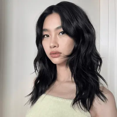 Hoyeon with a medium length shag haircut and face-framing bangs.