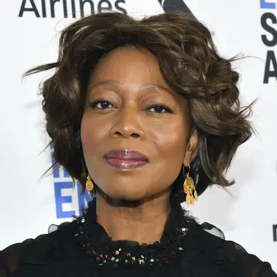 Alfre Woodard wears a short, dark hairstyle with mocha highlights