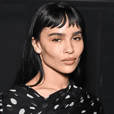 Sarah Hyland smirking at camera with hair in swoopy dark brown bob, chin length, bangs