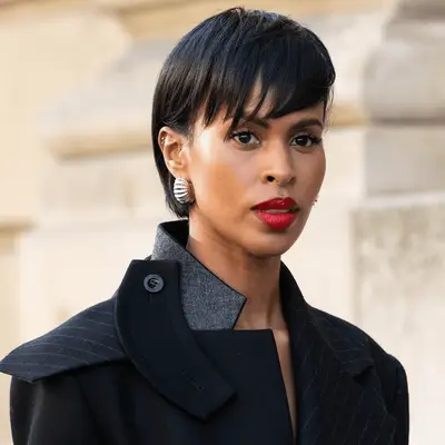 Zendaya looking over shoulder at camera with curly hair and bangs