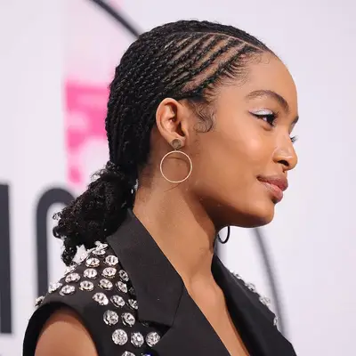 Yara Shahidi wears a short cornrowed low bun hairstyle