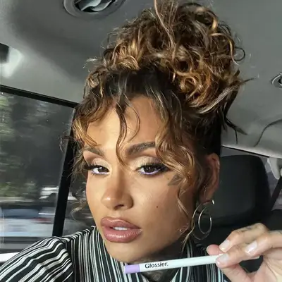 Kehlani wears a curly topknot hairstyle