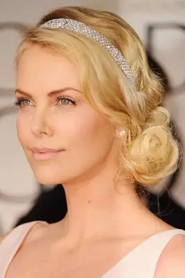 charlize theron with a curled low bun and sparkle headband