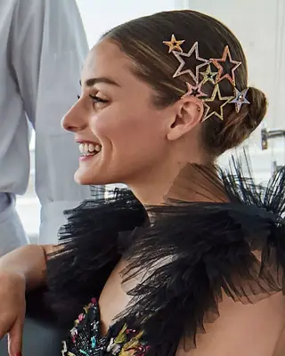 Olivia Palermo wears a low bun with colorful star clips