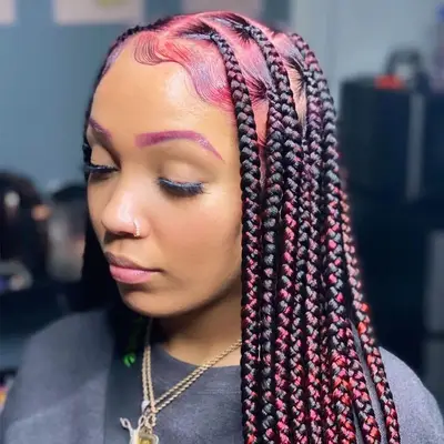 Woman wears a pink and black knotless braided hairstyle