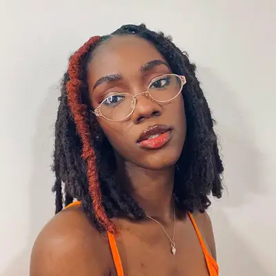 Woman wears a short faux locs hairstyle