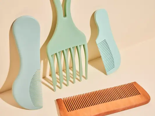 A neutral background with blue, green and brown combs in a composed image with shadows