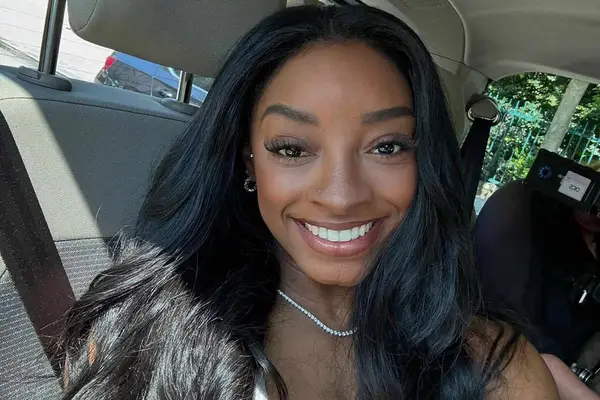 simone biles taking a selfie in the car