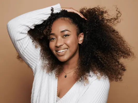 A woman with her hand in her curly hair
