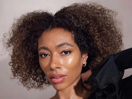 woman with curly hair looking at camera