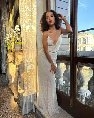 Kerry Washington wears her shoulder-length curls down and poses by a large window