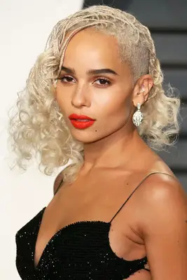 Zoe Kravitz wears in her platinum blonde hair in a half-shaved, half-micro-braided down hairstyle