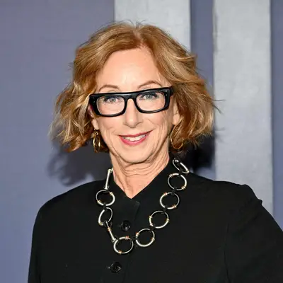 Michelle Satter with windswept, wavy bob and black-rimmed glasses