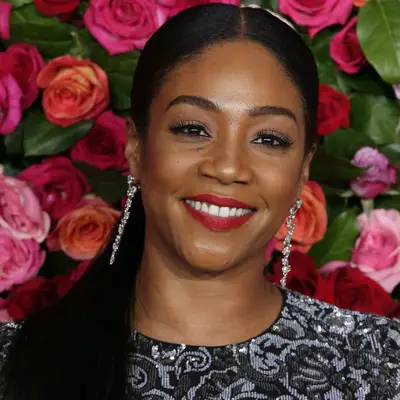 Tiffany Haddish wears a low, straight middle-parted ponytail