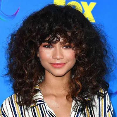 Zendaya wearing curls with face framing highlights 