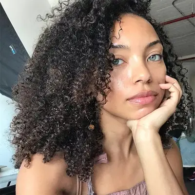 Logan Browning with side-parted curls