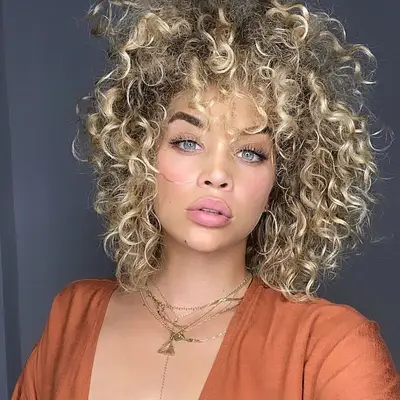 Jasmine Sanders with Balayage Blonde Hair in voluminous curls