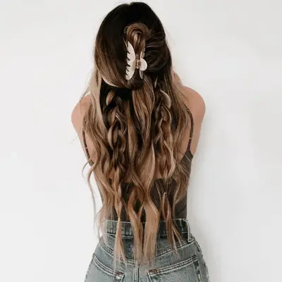 Back view of long ombre hair claw clipped half-up with accent braids on lower half