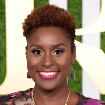 Issa Rae wears short copper natural curls and pink lipstick