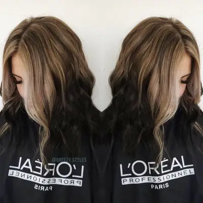 Woman with blonde to dark brown reverse ombré hair with money pieces