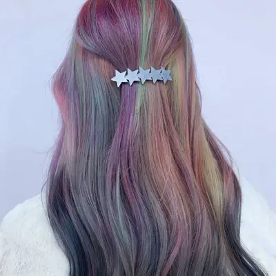 Woman with rainbow to gray reverse ombré hair with star barrette