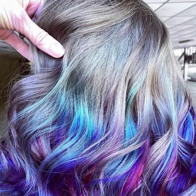 Woman with gray to multicolored blue and purple reverse ombré hair