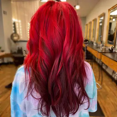 A woman showing a back view of red reverse ombré hair