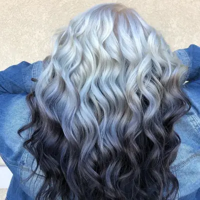 Woman showing the back of black to white curled reverse ombré hair