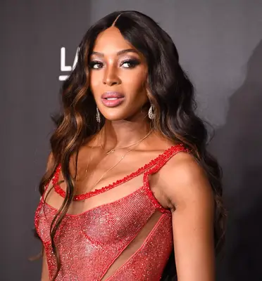 Naomi Campbell long, wavy hair with caramel highlights