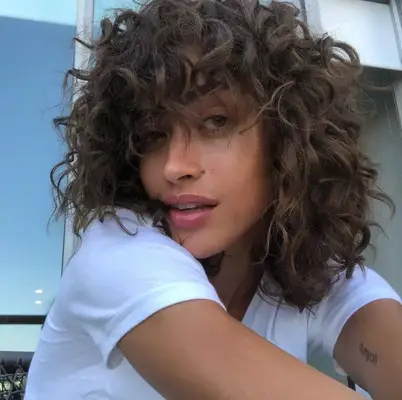 Alanna Arrington wears a curly shag hairstyle
