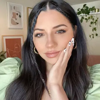 Justine Marjan wears long, sleek hair with face-framing accent braids